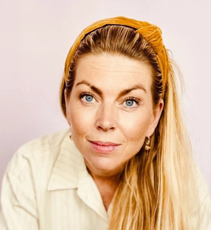 Sort-hvide foto af en ældre person med kort, gråt hår og briller, iført en hvid skjorte.