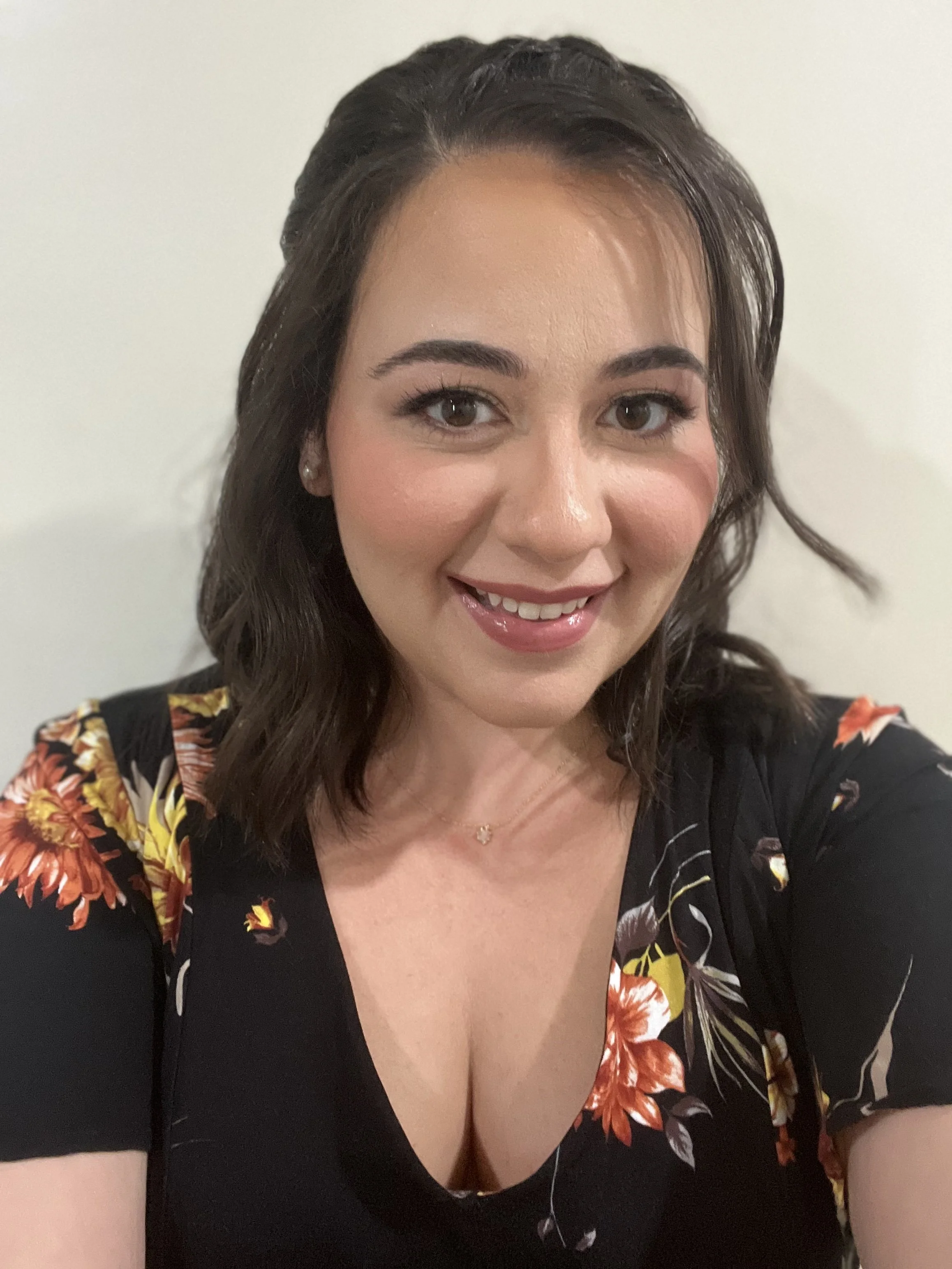 Woman smiling in floral dress against white background