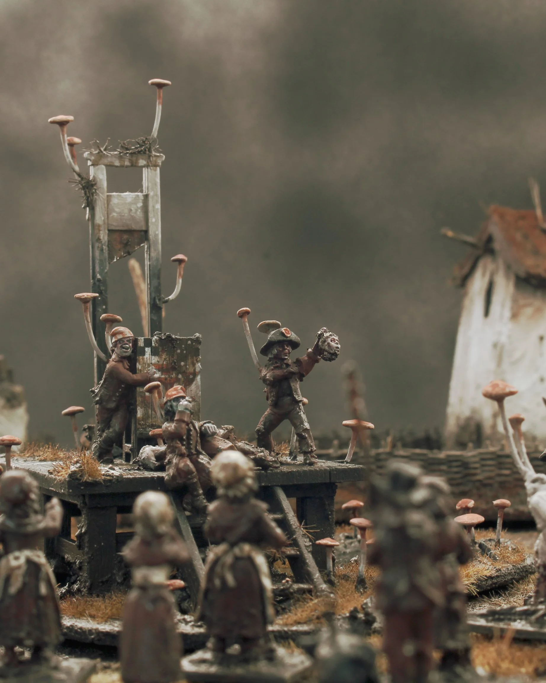 Miniature figurines of soldiers and mushrooms on a diorama set, representing a historical battlefield scene.