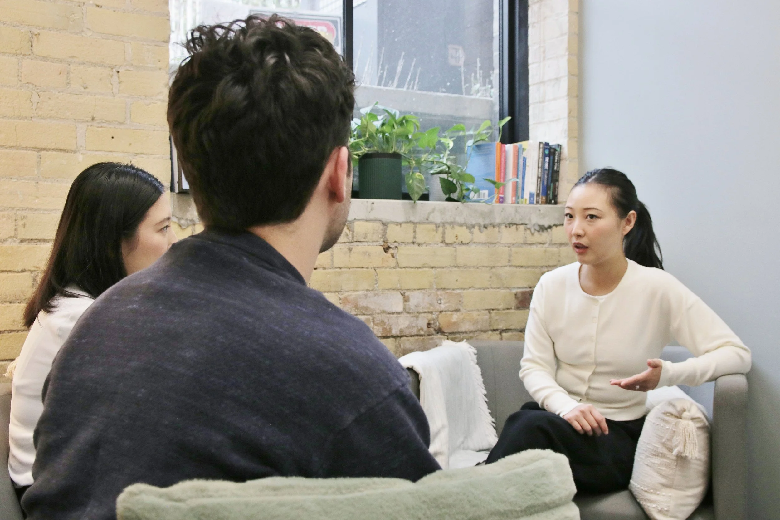 Lifei Qian, a True Resilience Psychotherapy psychotherapist poses in a couples therapy session with fighting couple.