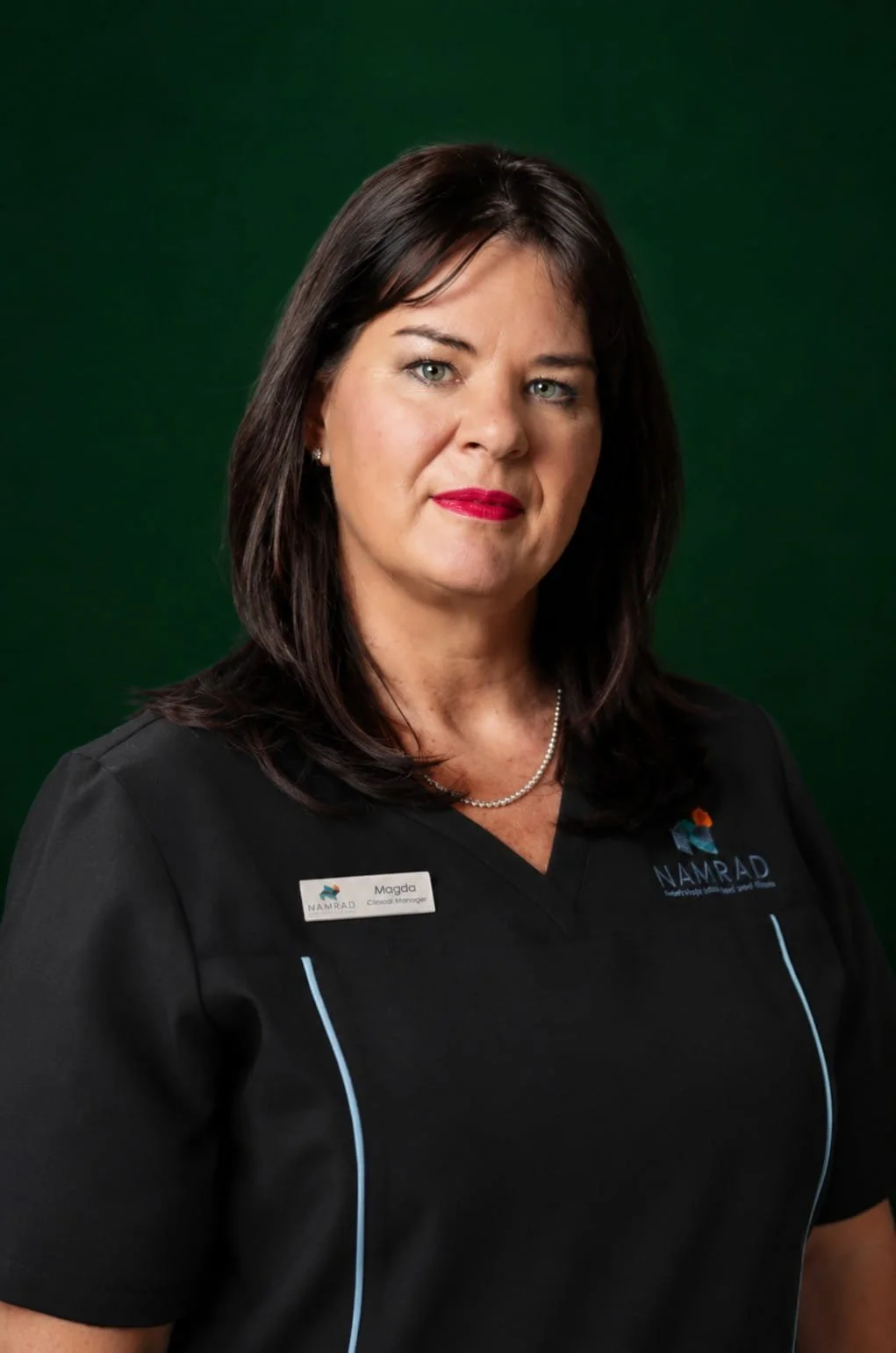 Person wearing a black medical uniform with Namibia Radiology logo, green background.
