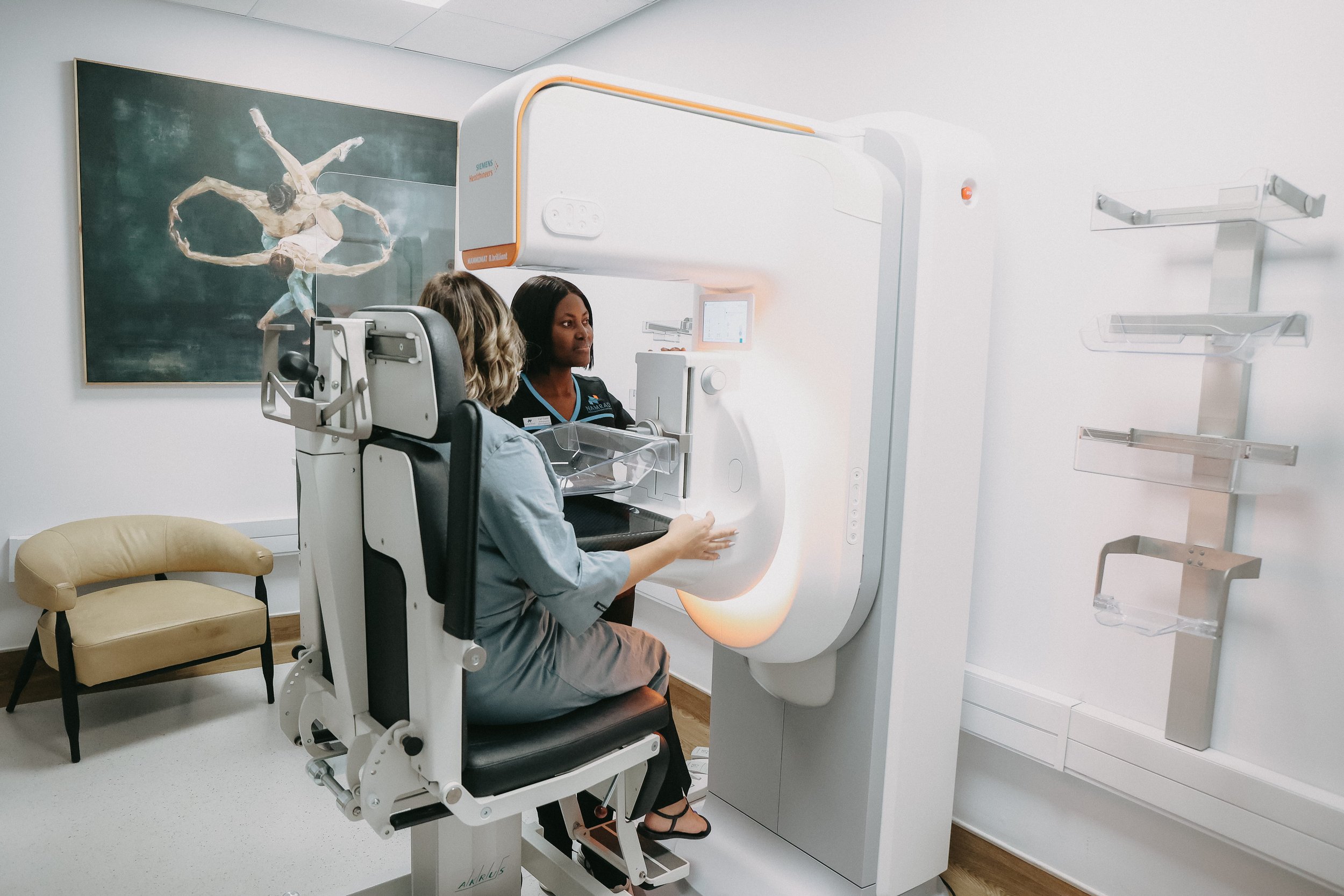 Radiographer performing a mammogram on a patient