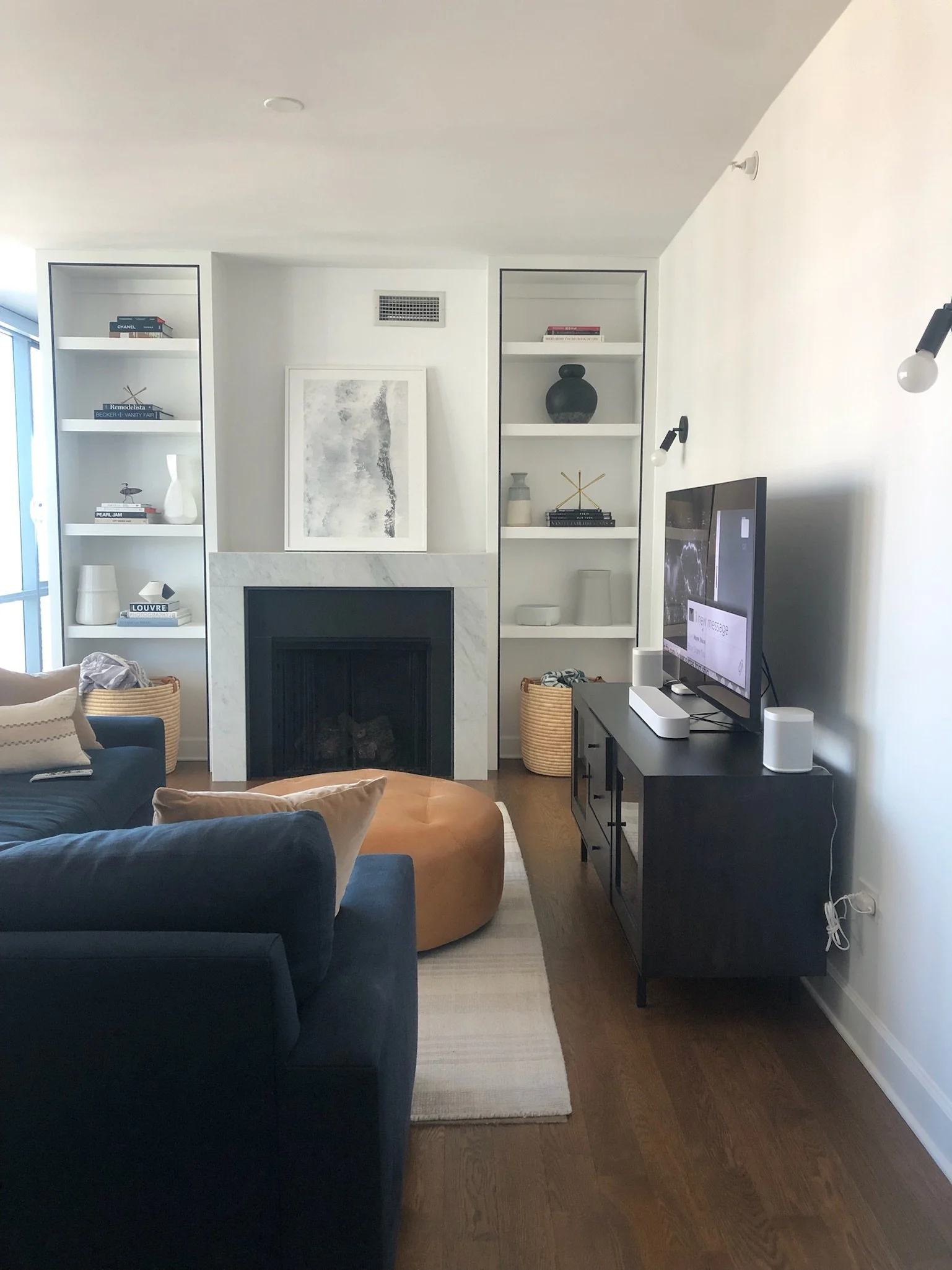 Living room with a fireplace, built-in shelves, a black TV stand, and a flat-screen TV.