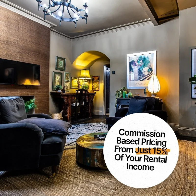 Living room interior with dark sofas, a wooden coffee table, wall-mounted TV, framed artwork, table lamps, and houseplants. A circular overlay with text advertising a rental fee of 15% based on commission pricing.