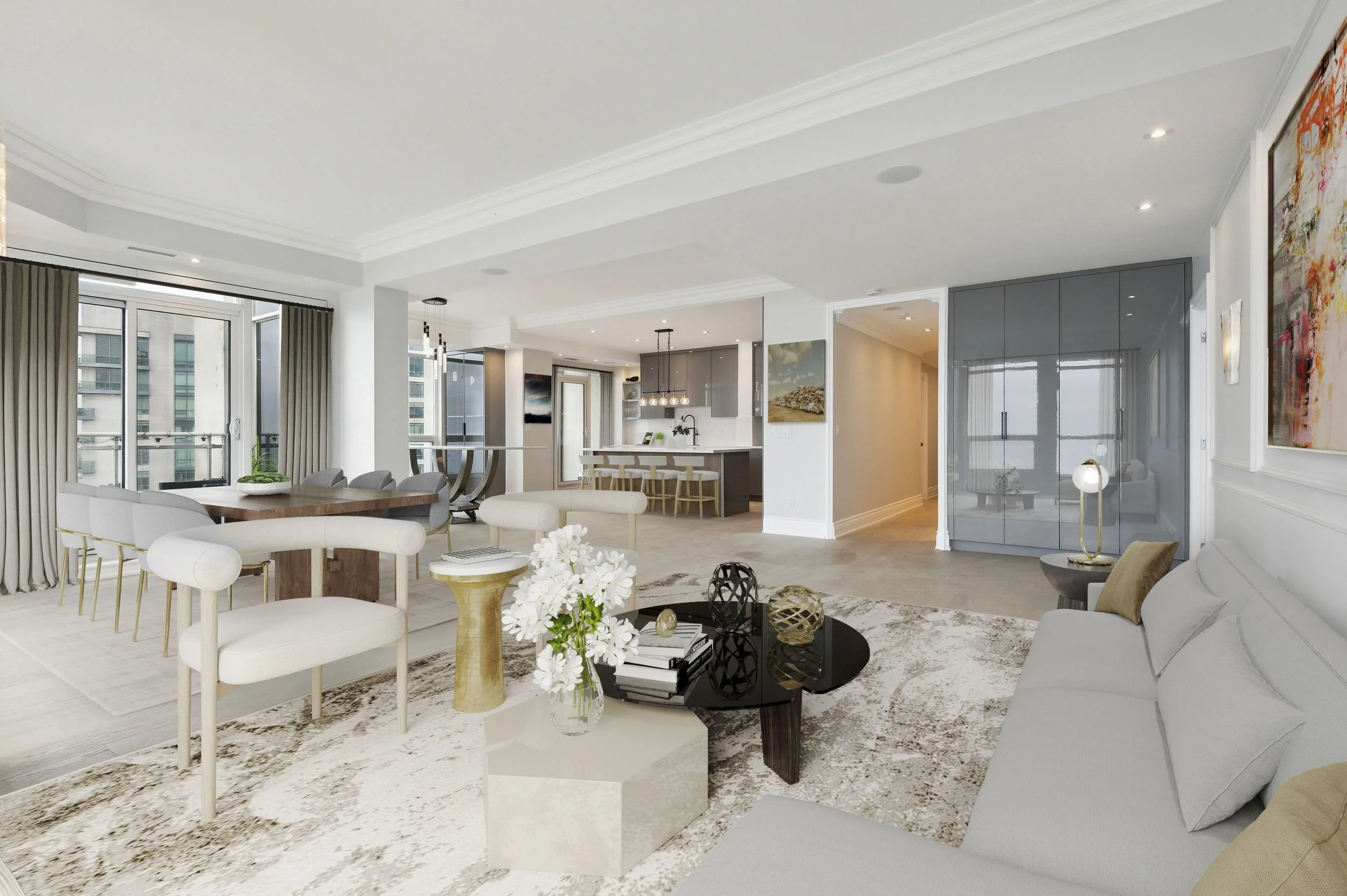 Modern, open-concept living room with dining area and kitchen in the background. Features a white sofa, black coffee table with decorative objects, white chairs with gold legs, large windows with curtains, and artwork on the walls.