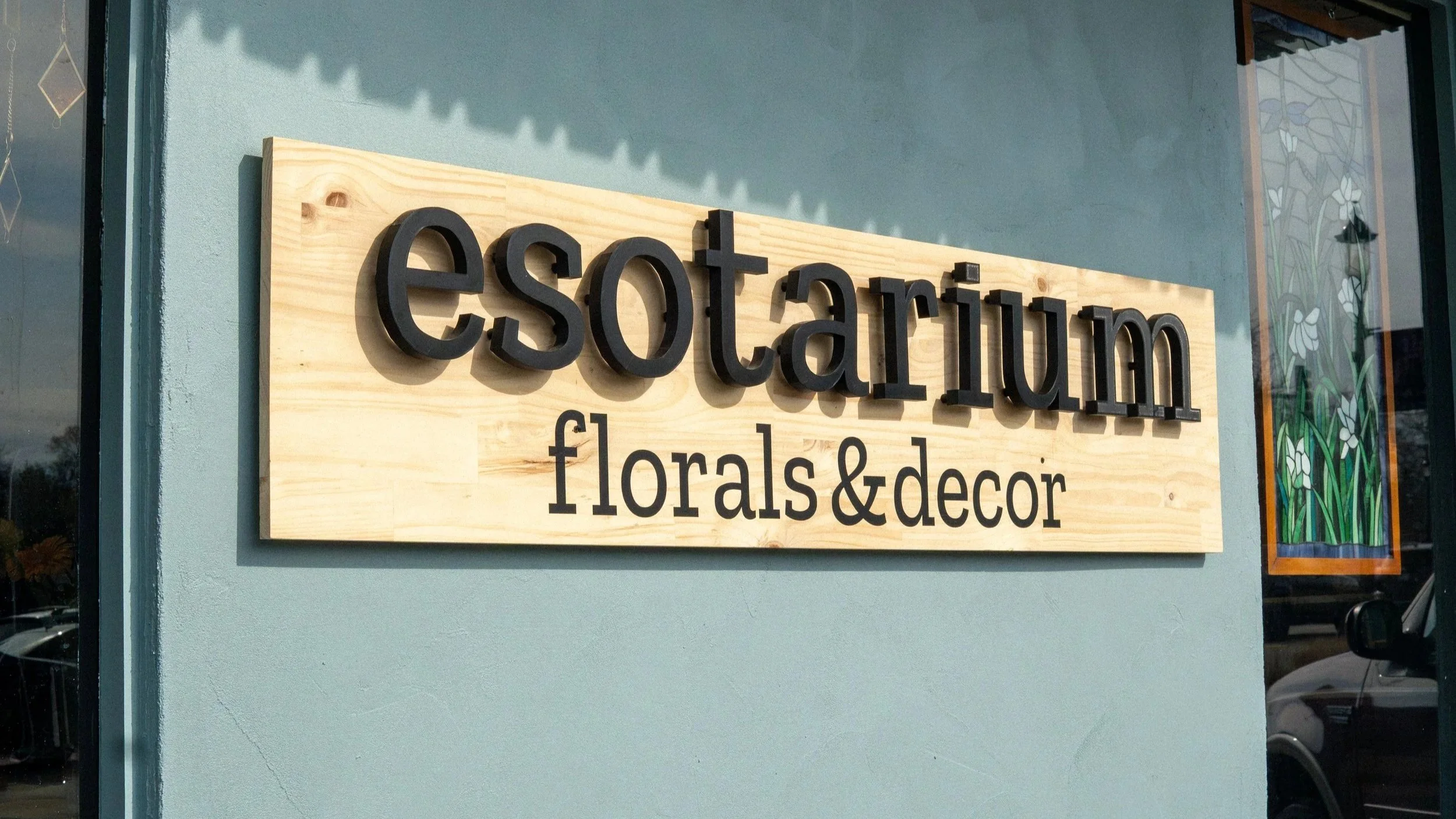 The Esotarium florals and decor sign in the studio window.