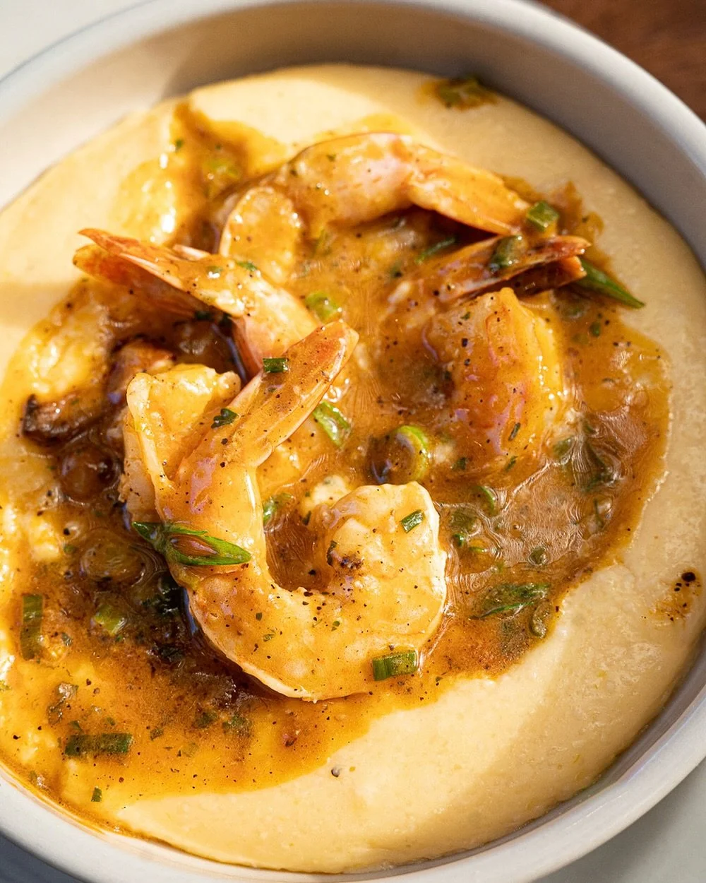Lowcountry Shrimp &amp; Grits 😍 Five jumbo shrimp saut&eacute;ed in our signature tomato-garlic sauce with smoky bacon, served over creamy cheddar grits. Comes with two over-medium eggs and a warm buttermilk biscuit.⁠
⁠
#screendoorpdx #pdxfood #port