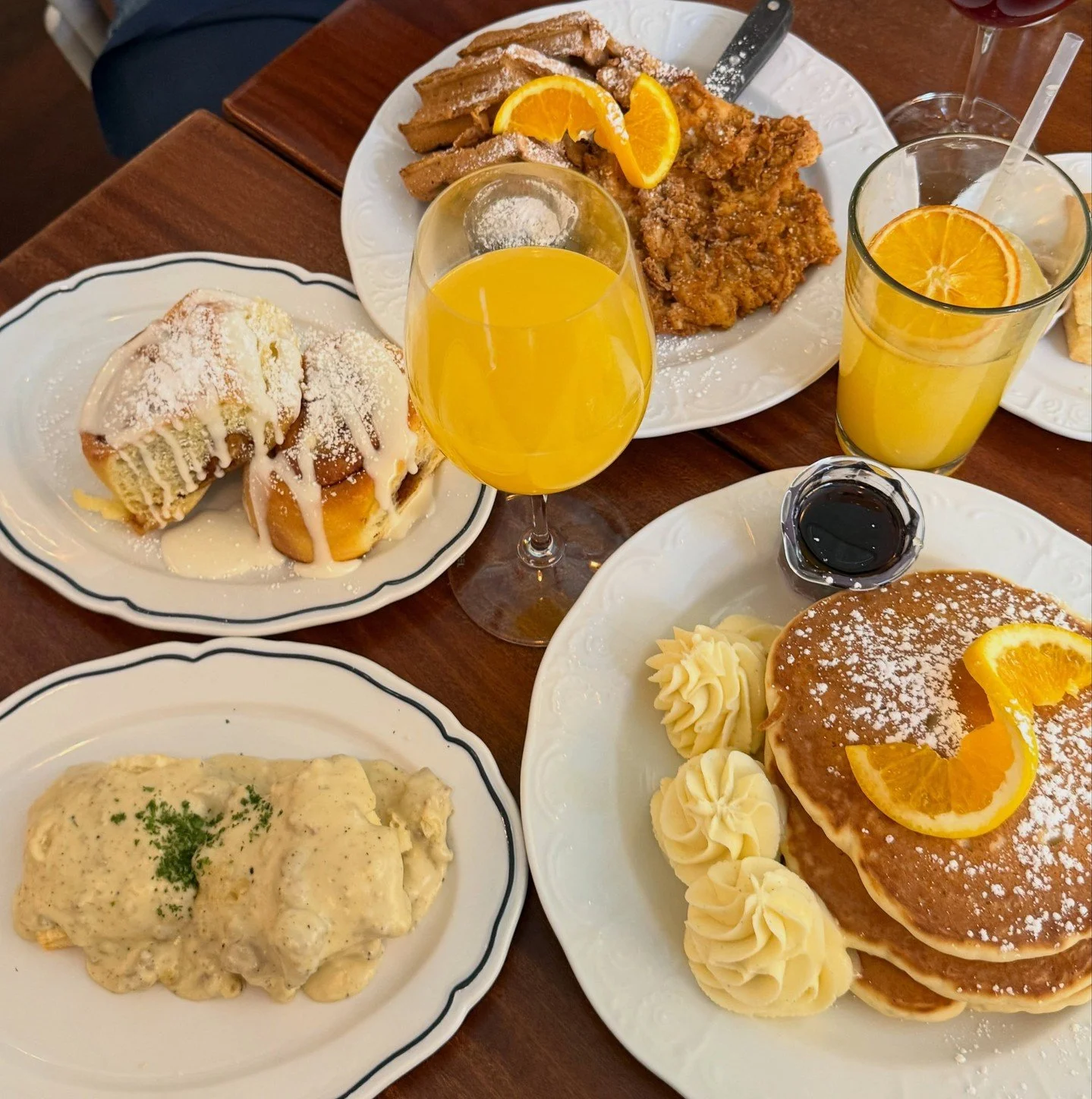 If you're wondering what to order, take a cue from @filmedwithmia&rsquo;s brunch spread. Buttermilk-battered chicken and waffles, fluffy pancakes, cinnamon rolls, and a mimosa on the side just to name a few.⁠
⁠
Join us for brunch daily from 8:30am&nd
