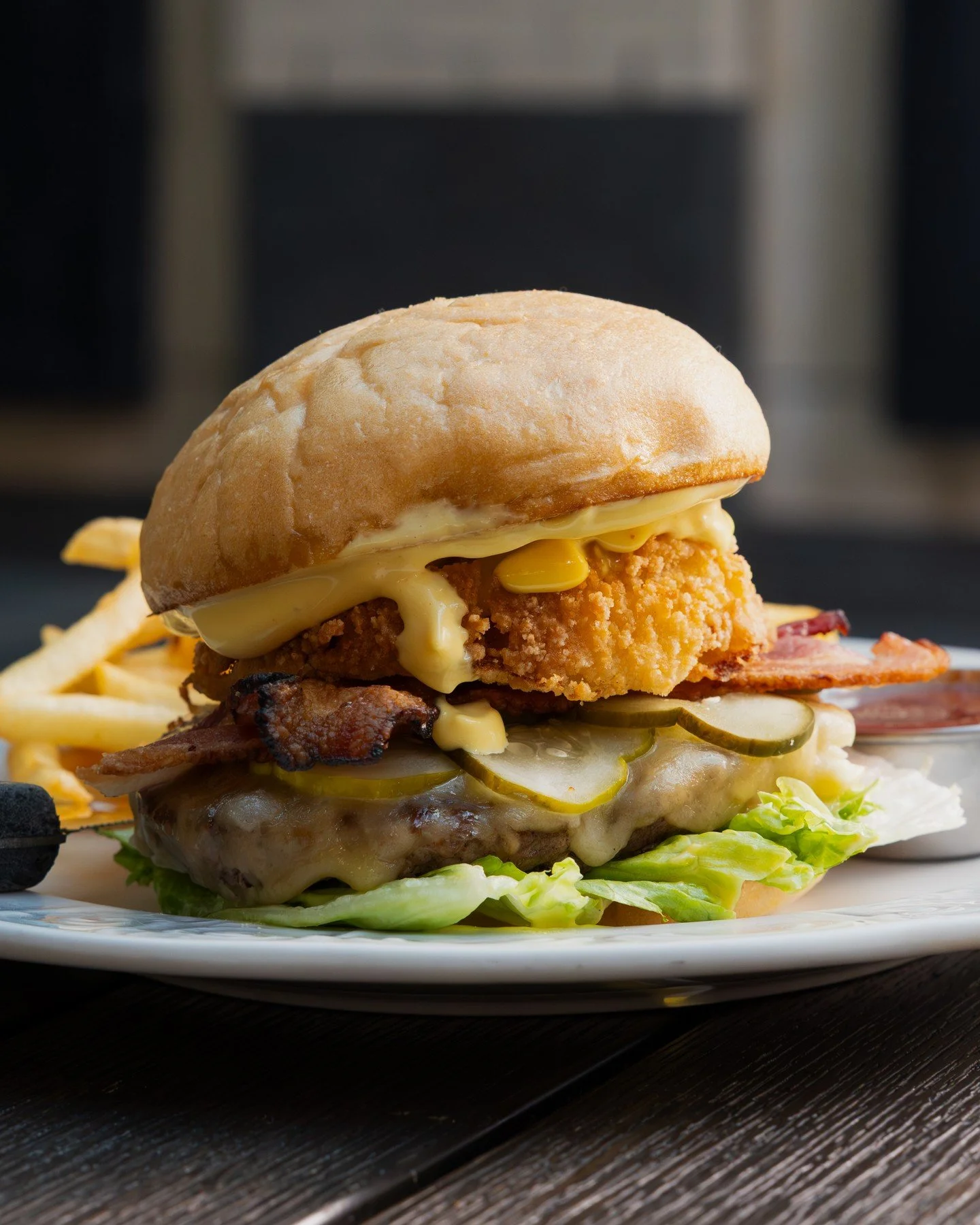 If summer were a burger, it would be this one 🍔 The Carolina Gold Burger features a 6 oz. griddled St. Helens beef patty, mustard BBQ aioli, a house-made onion ring, bacon, lettuce, pickles, and Wisconsin havarti on a toasted potato bun, served with