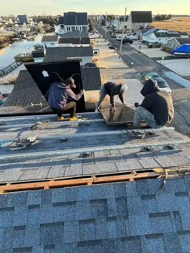 GRM Roofing contractors repairing solar panels on a residential roof in Little Egg Harbor, NJ