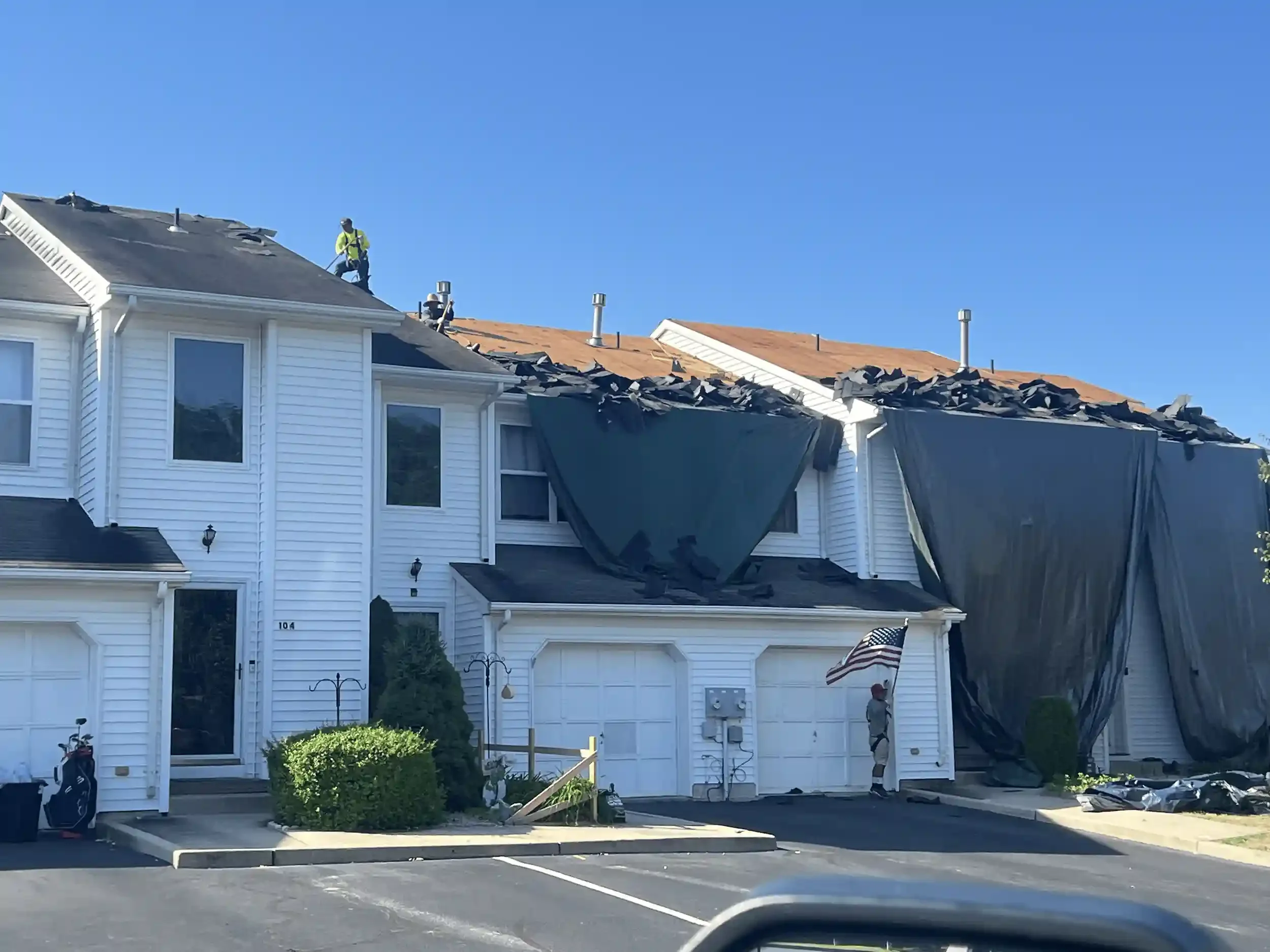 GRM Roofing crew tearing off old shingles during a townhome roof replacement in Ocean County, NJ