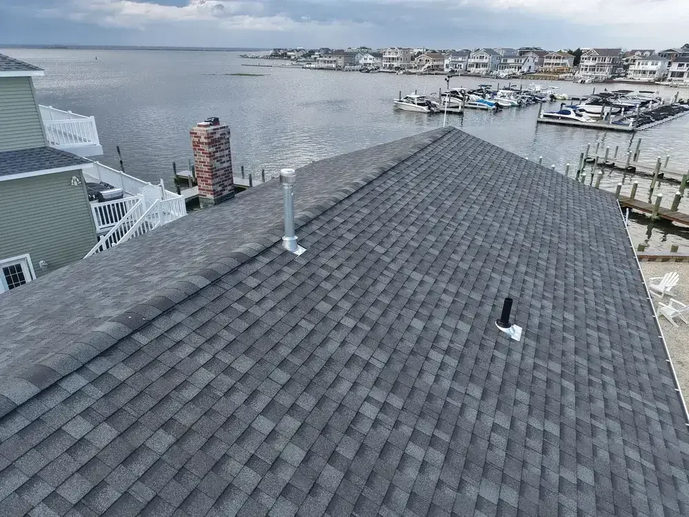 Professional roofer fixing storm damage on a residential roof in Southern NJ