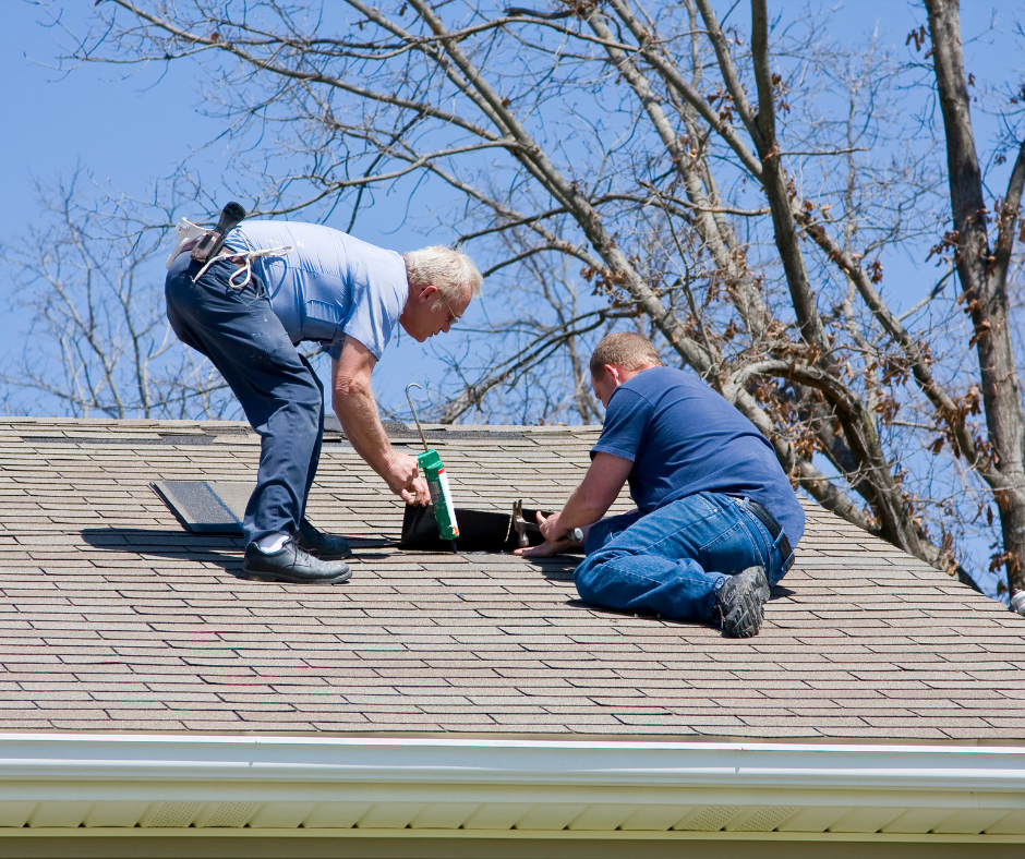 Two roofing professionals sealing a roof vent boot with caulk to prevent leaks on a Toms River NJ home