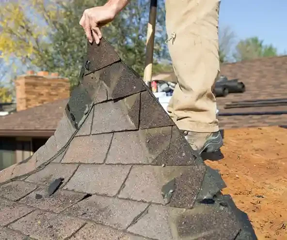 Roofer removing storm damaged shingles during a roof repair in Little Egg Harbor, NJ by GRM Roofing