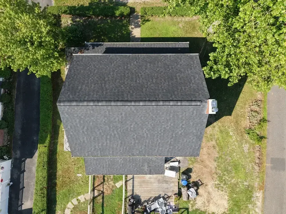 GRM Roofing team members carrying shingles to a job site in Southern NJ
