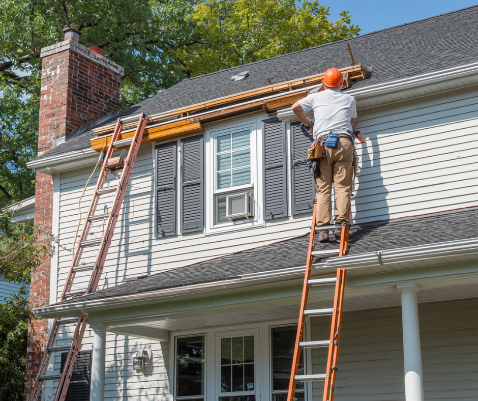 Roofing contractor on a ladder repairing the roof edge of a two-story home in Little Egg Harbor, NJ