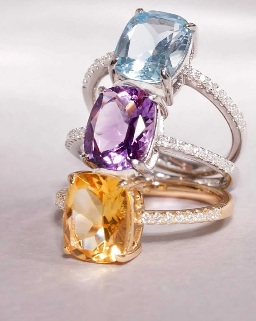 Conjunto de três anéis com pedras coloridas e detalhes em diamantes.