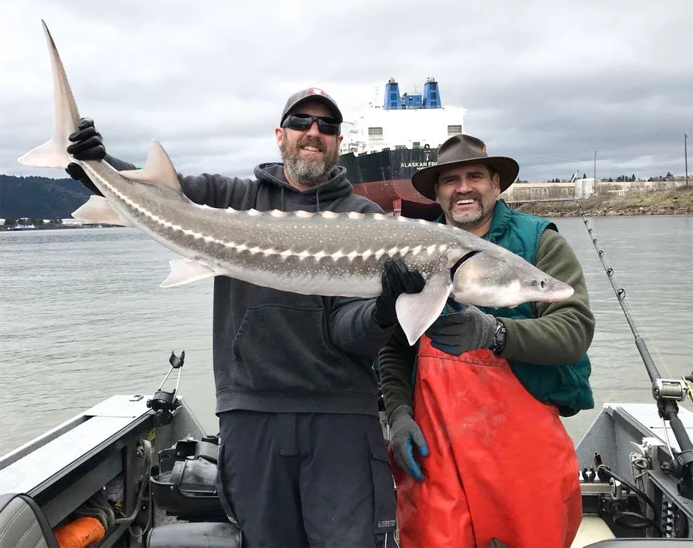 2 men holding sturgeon caught with fishing charter service in Astoria, Oregon