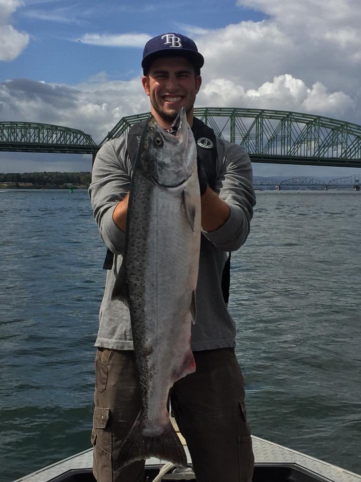 fisherman holding up silver chinook salmon caught with fishing charter in Oregon
