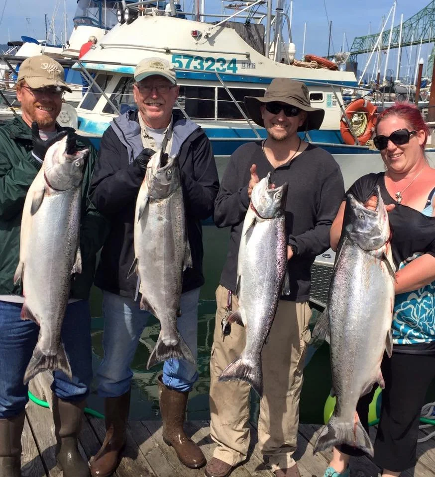fishermen holding up silver chinook salmon caught with fishing charter in Oregon