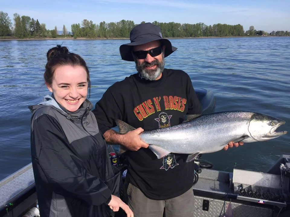 fisherman holding up silver chinook salmon caught with fishing charter in Oregon