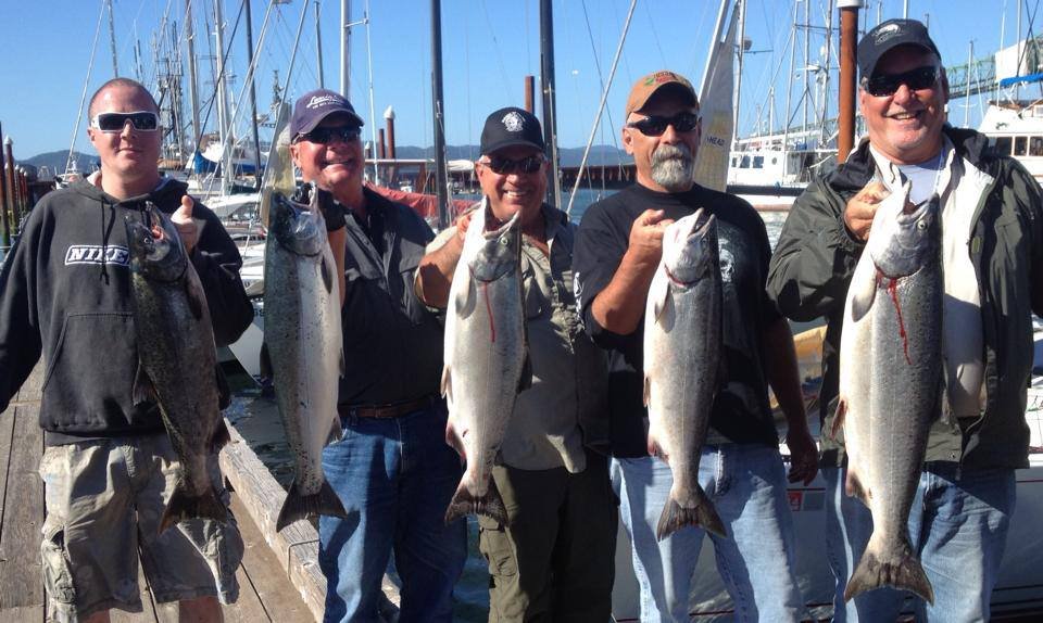 fishermen holding up silver chinook salmon caught with fishing charter in Oregon