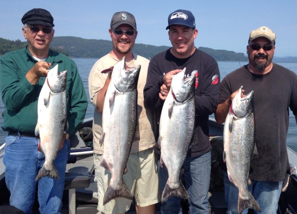 fishermen holding up silver chinook salmon caught with fishing charter in Oregon