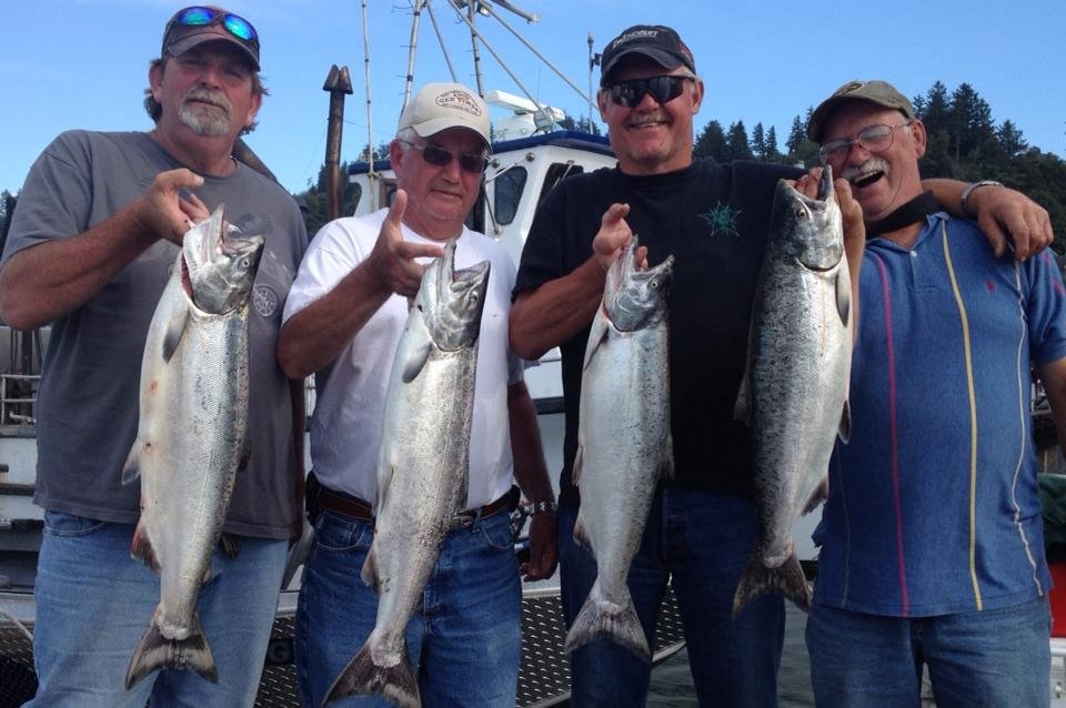 fishermen holding up silver chinook salmon caught with fishing charter in Oregon