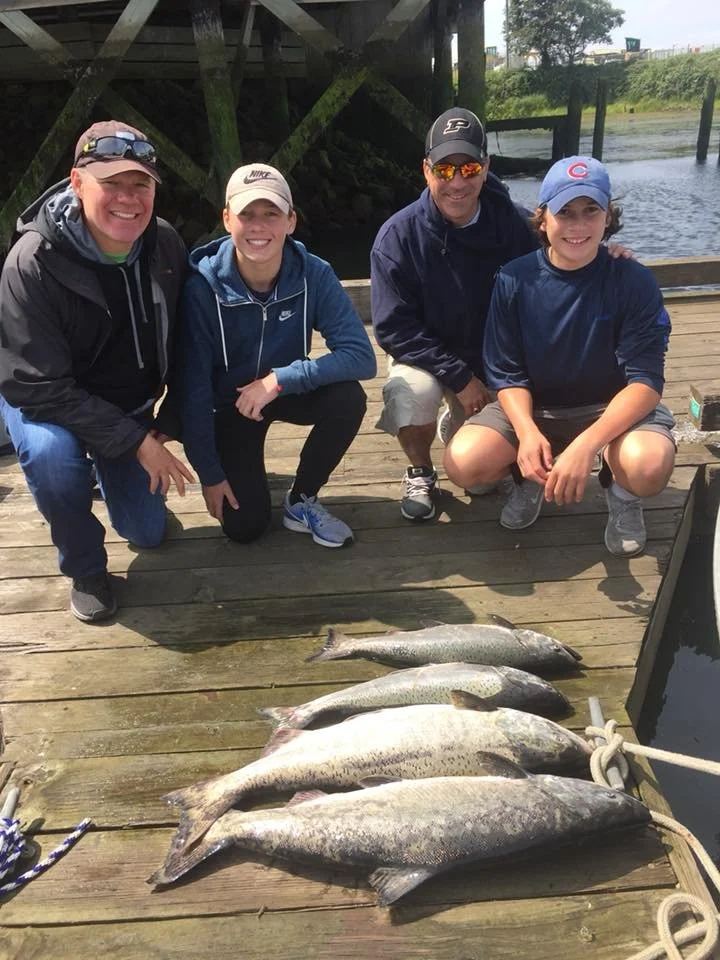 Family showing off the 4 salmon they caught fishing in Oregon