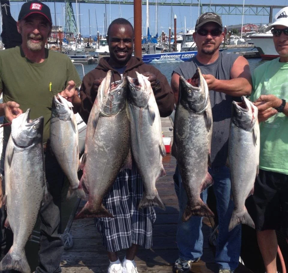 fishermen holding up silver chinook salmon caught with fishing charter in Oregon