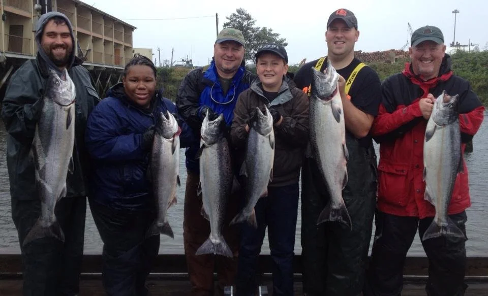 fishermen holding up silver chinook salmon caught with fishing charter in Oregon
