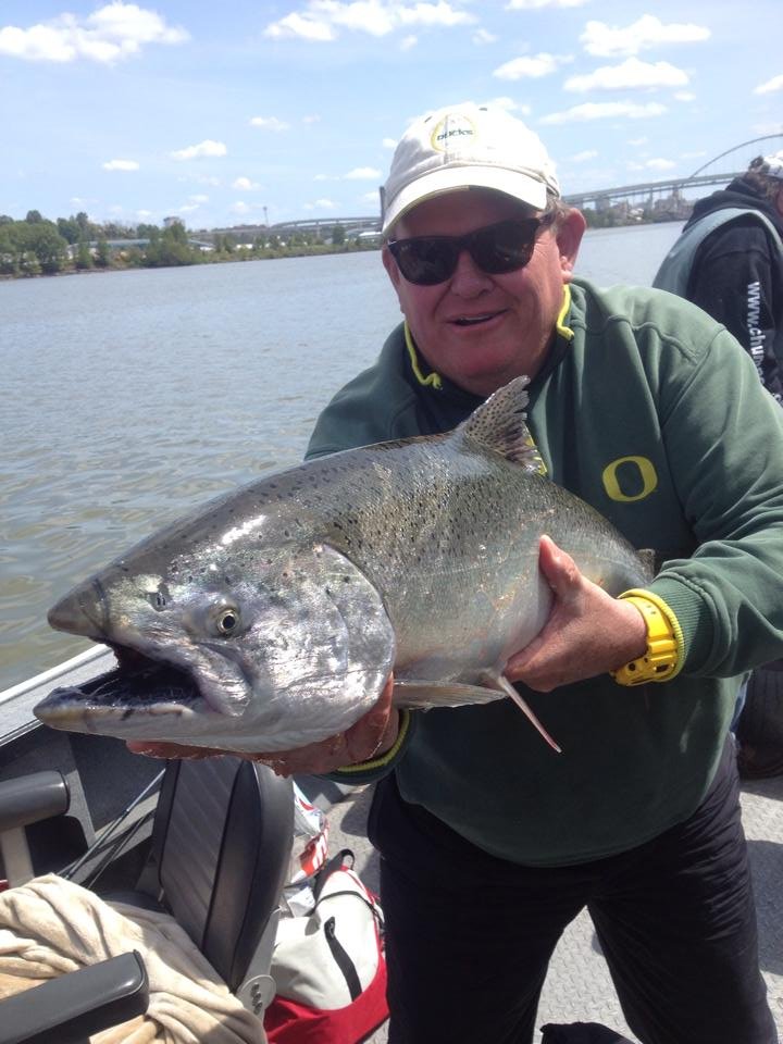 fisherman holding up silver chinook salmon caught with fishing charter in Oregon