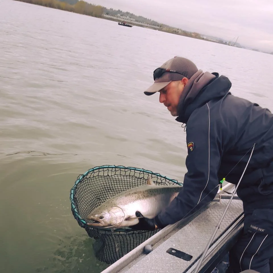 fisherman catching silver chinook salmon caught with fishing charter in Oregon