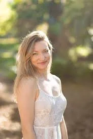 Jess Mather, strength training and nutrition expert for women, smiling confidently in an active, empowering setting, embodying strength, wellness, and balanced nutrition.