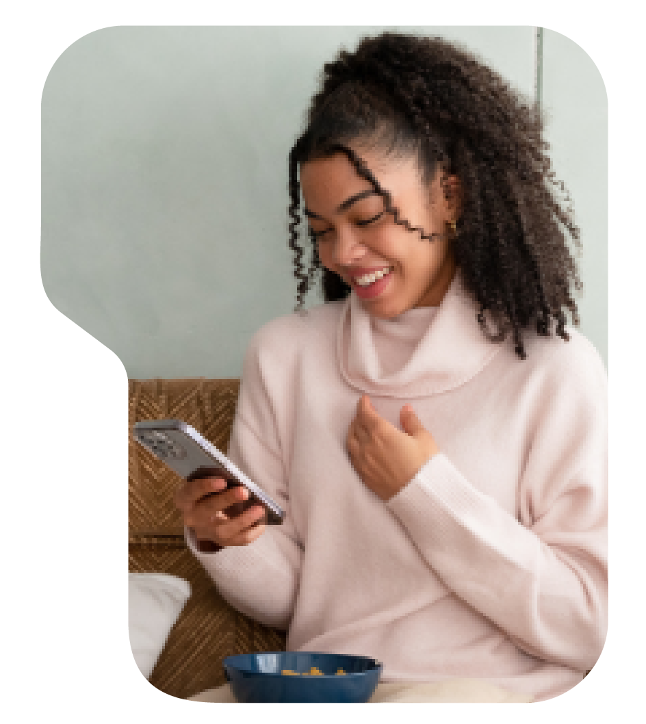 young woman looking at phone smiling.png