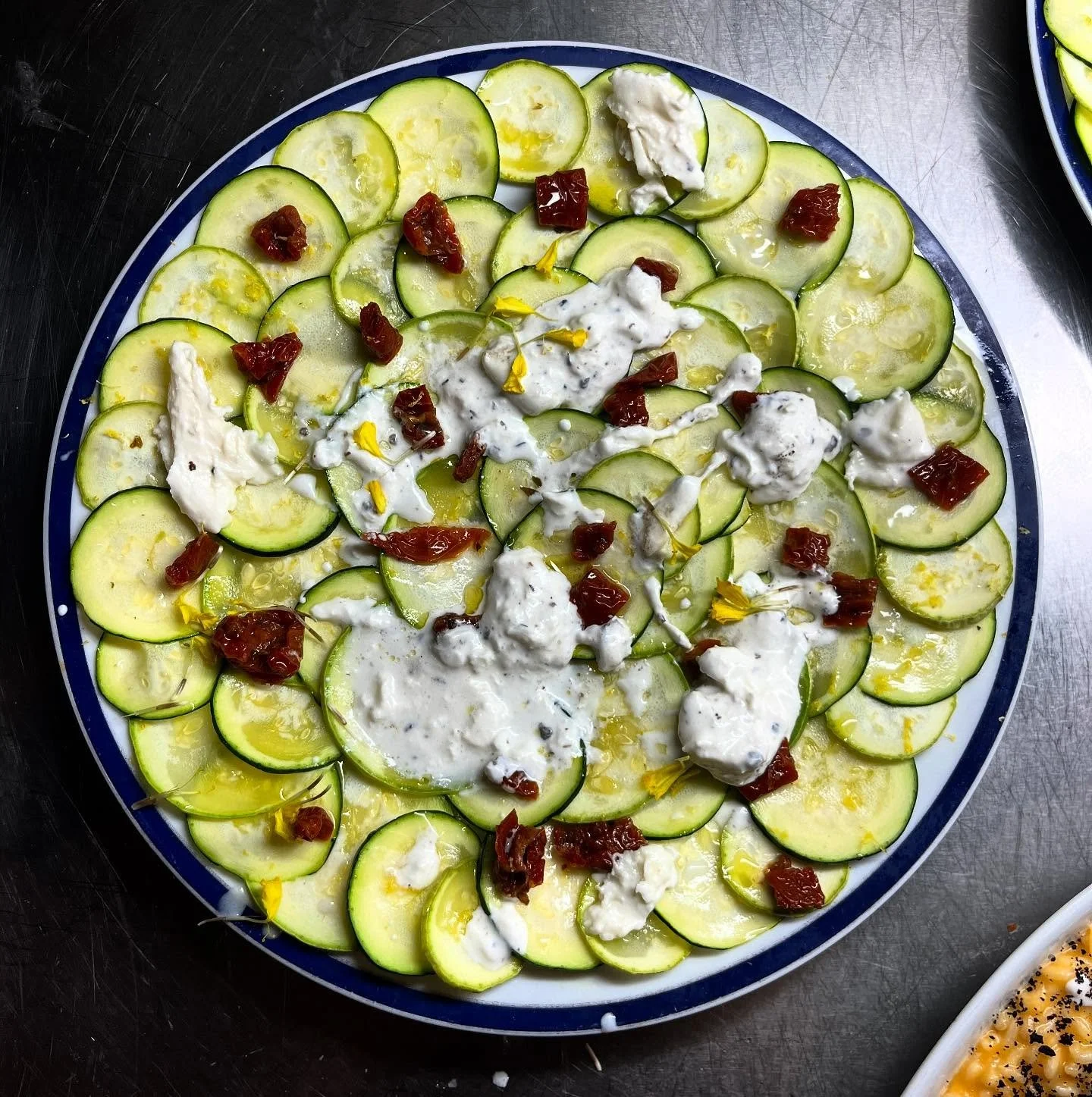 🌿 Fresh, vibrant, and indulgent.
White and green zucchini carpaccio marinated with lemon, sun-dried tomato, and truffle buffalo stracciatella.
A Mediterranean summer on the plate &mdash; light, yet full of character.
Crafted in Mallorca with passion
