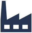 Silhouette einer Fabrik mit Schornstein vor dunklem Himmel.