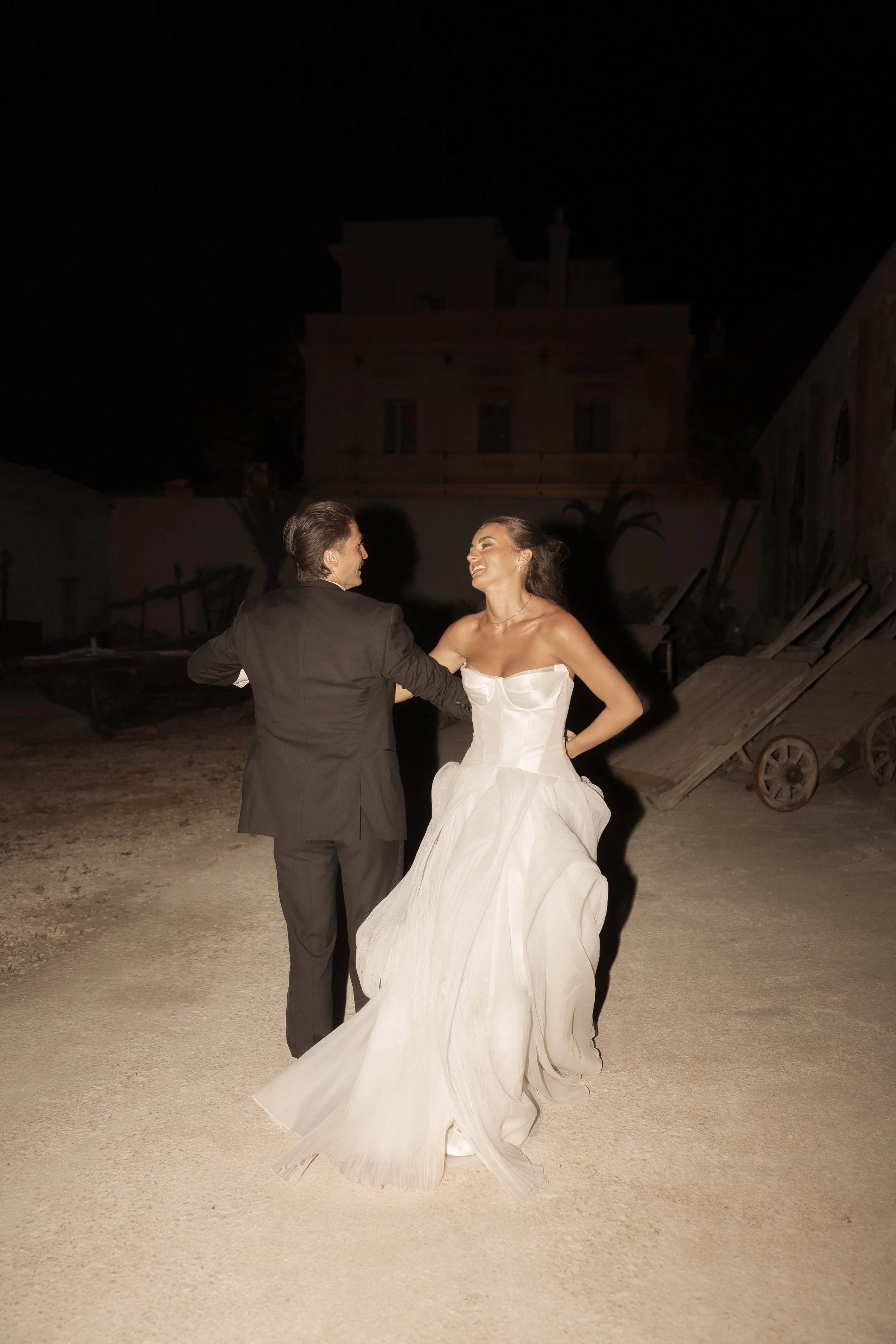 Candid wedding photograph of Savannah and Todd laughing and dancing together at Camparia Favignana during their destination wedding in Sicily.