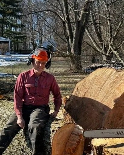 Brent sitting on a massive tree he removed in Cincinnati Ohio