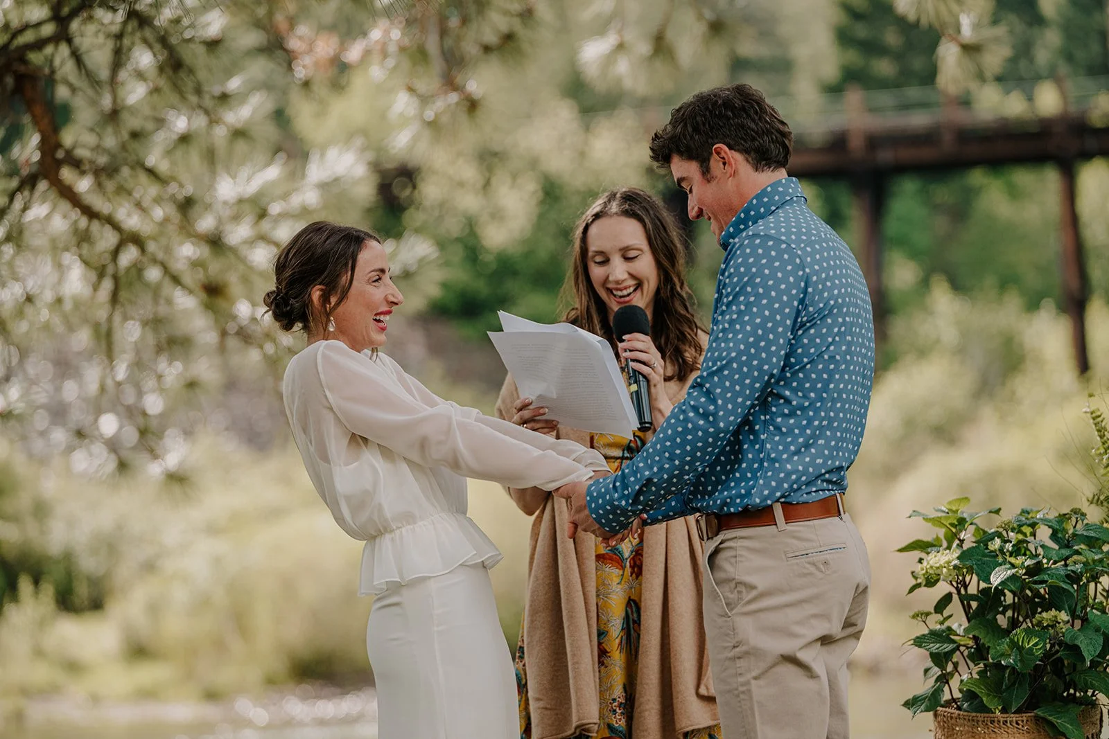 Bride and groom laughing at the alter during an outdoor wedding ceremony at private venue in Missoula, MT.