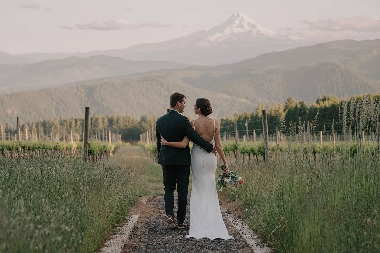 Bride and groom looking out at Mt. Hood from the vineyard rows at Gorge Crest Vineyards, Hood River Oregon, photographed by Jen Jones Weddings