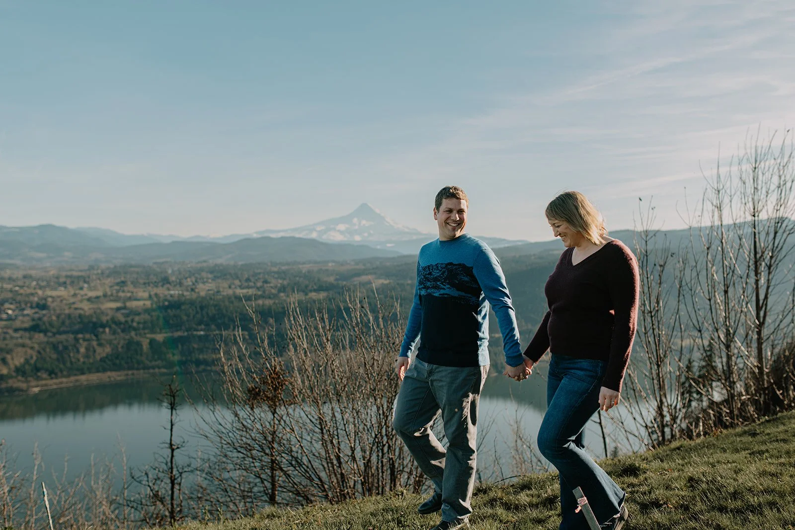 Candid photo of couple during engagement photo session along the Columbia River with Mt. Hood in background.