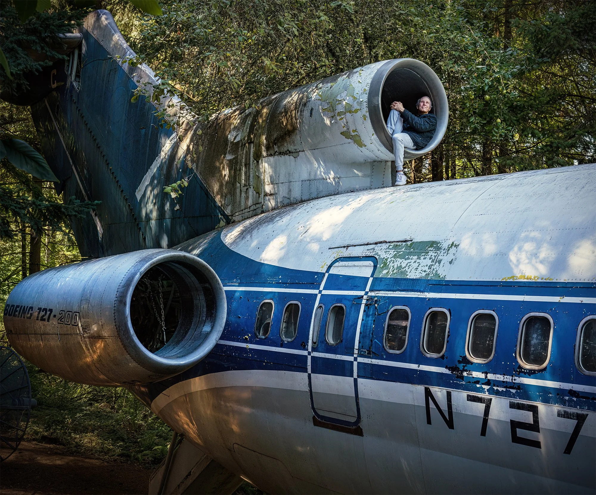 Bruce Campbell perched in the No. 2 engine nacelle of his 1969 Boeing 727-200  airplane home. Hillsboro, Oregon. 2023.