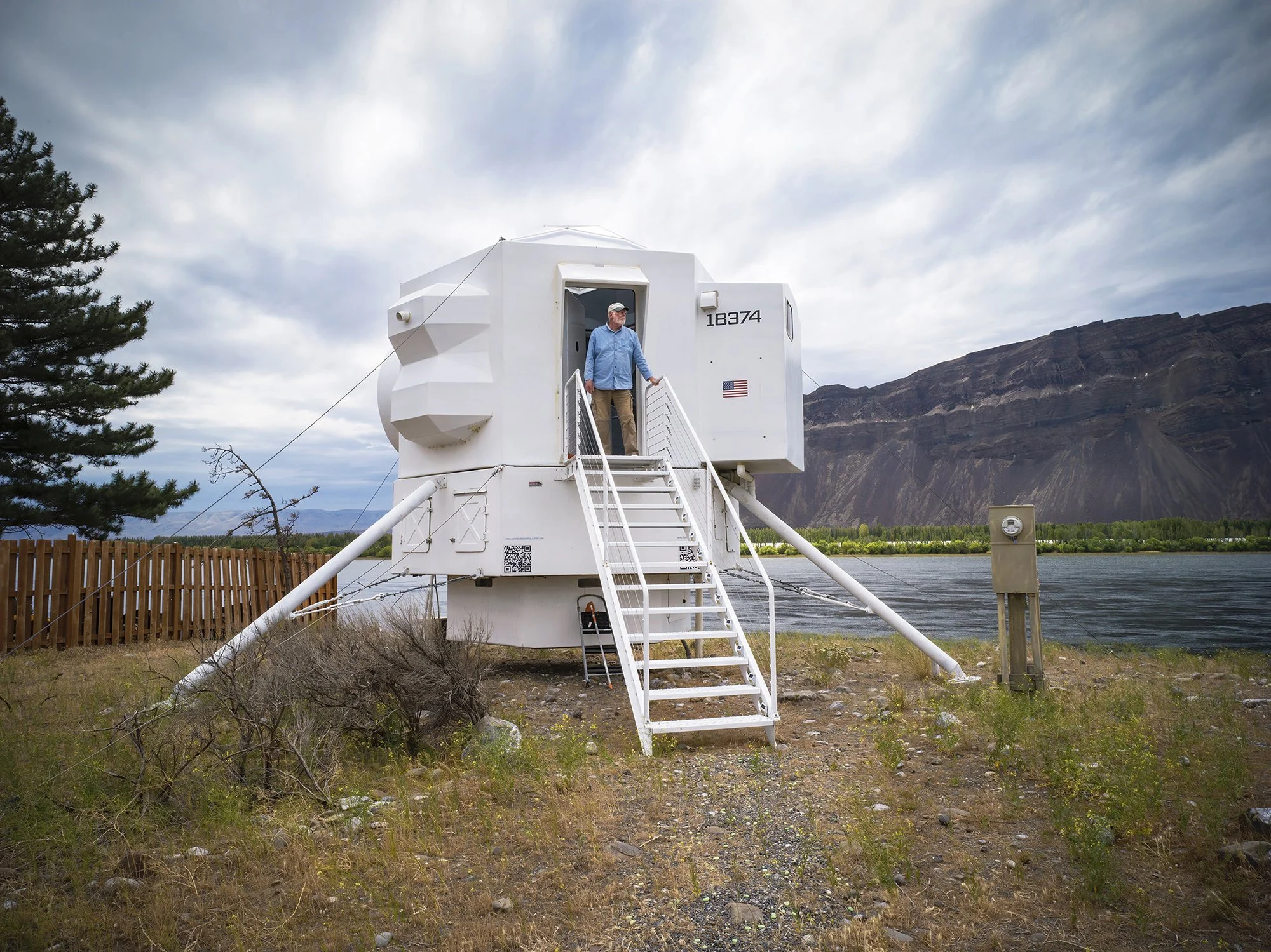 Kurt Hughes looking out over the Columbia River from his Lunar Lander tiny home. Beverly, Washington. 2021.