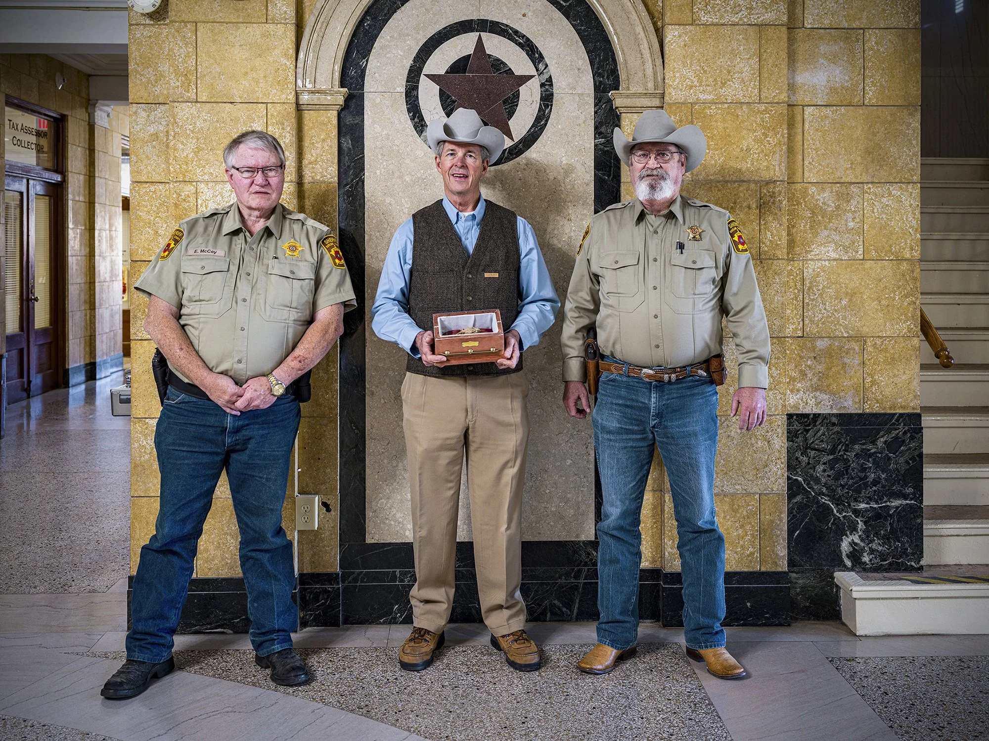 Judge Rex Fields, center, with deputies in the Eastland County Courthouse, holding the remains of Ol’ Rip, a horn toad who survived 31 years encapsulated in the Courthouse time capsule. Eastland, Texas. 2021.