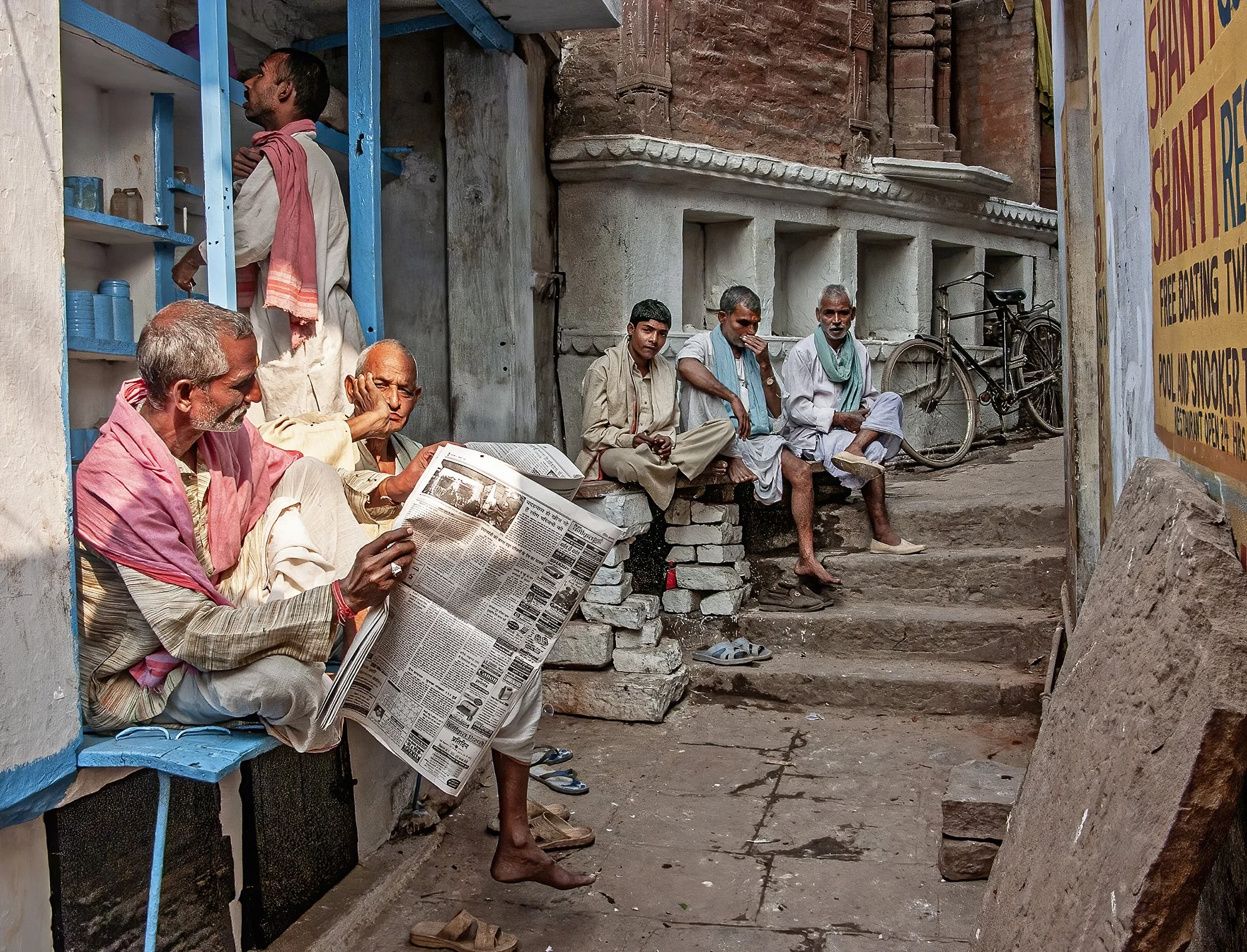 Men sipping chai and reading the newspaper. Varanasi.