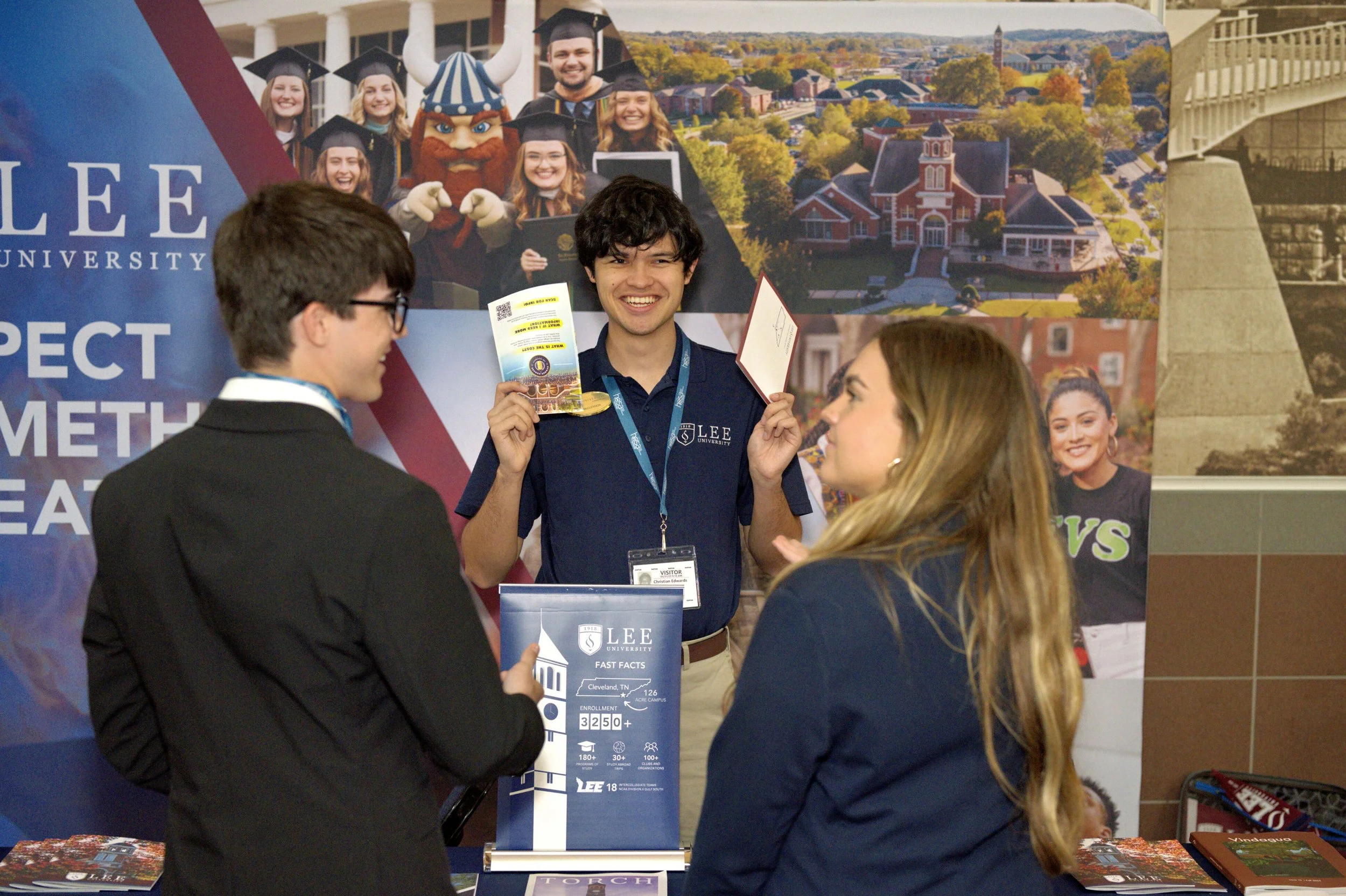 Two HOSA members interact with a college booth at the College and Career Fair.