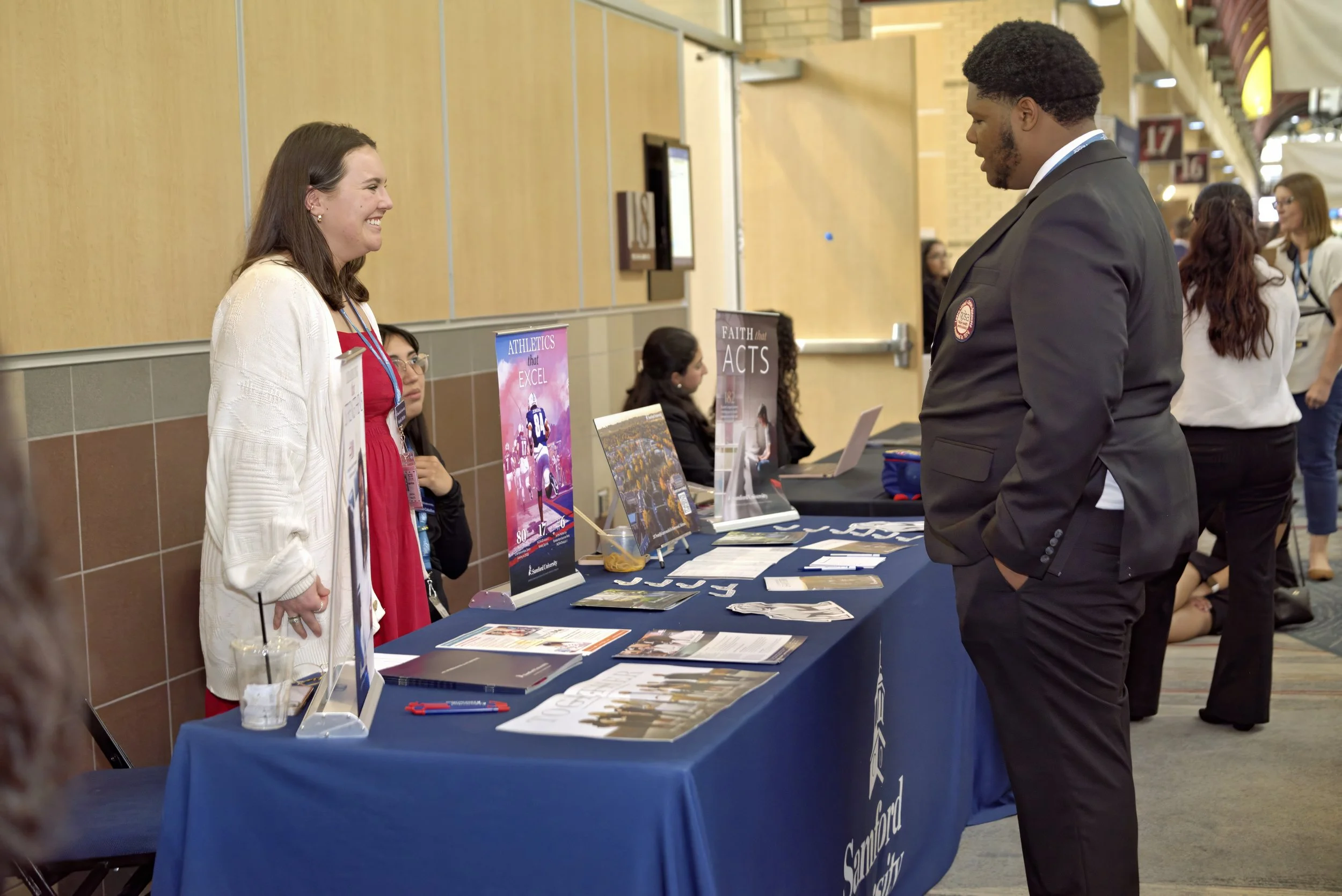 A HOSA student member interacts with an exhibitor at the college and career fair.