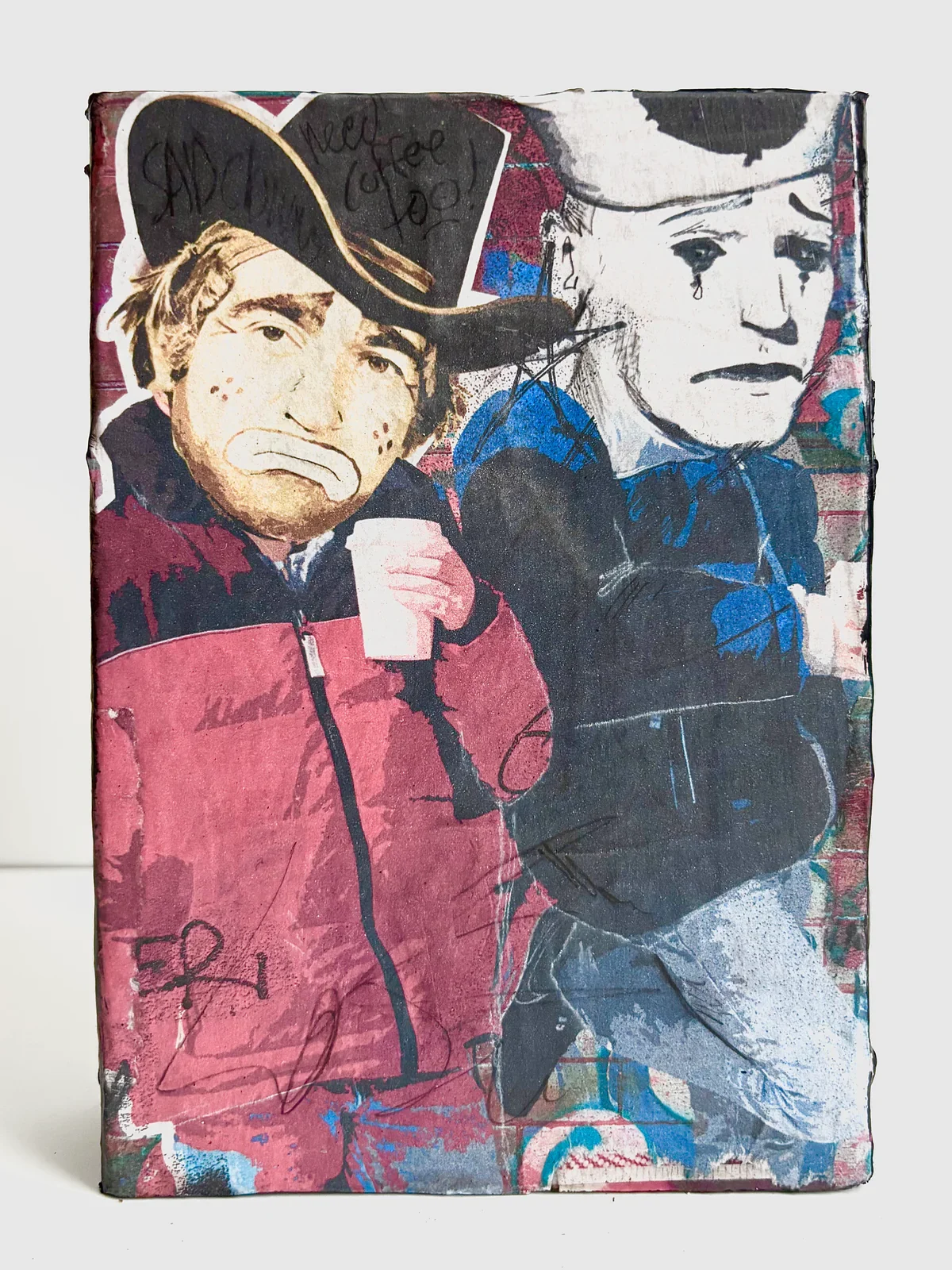 Street art mural of two people wearing hats, with one holding a cup, graffiti elements, and stylized text.