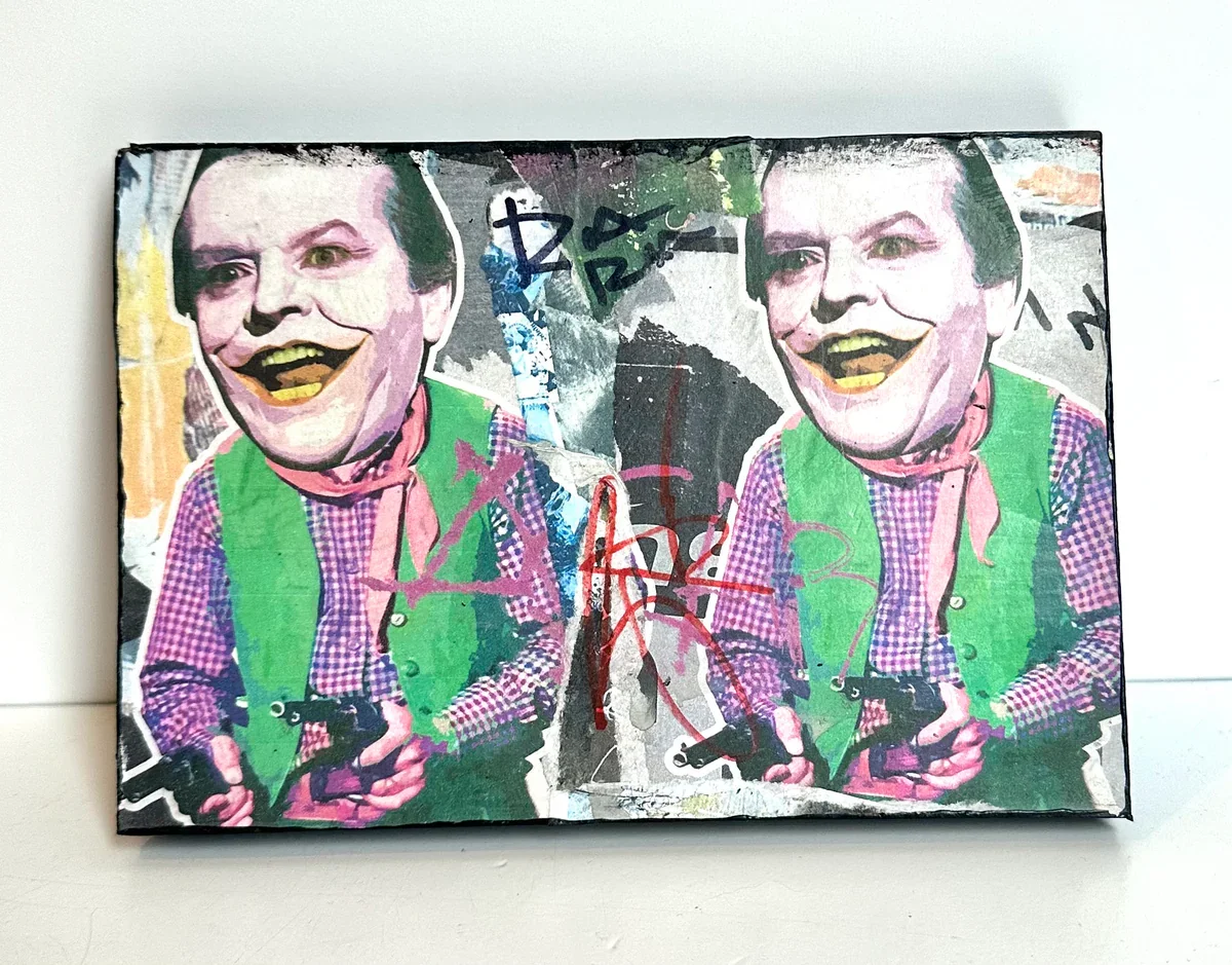 Mixed media artwork featuring two identical figures with exaggerated facial features, green vests, checkered shirts, holding guns, and surrounded by colorful abstract elements and graffiti.